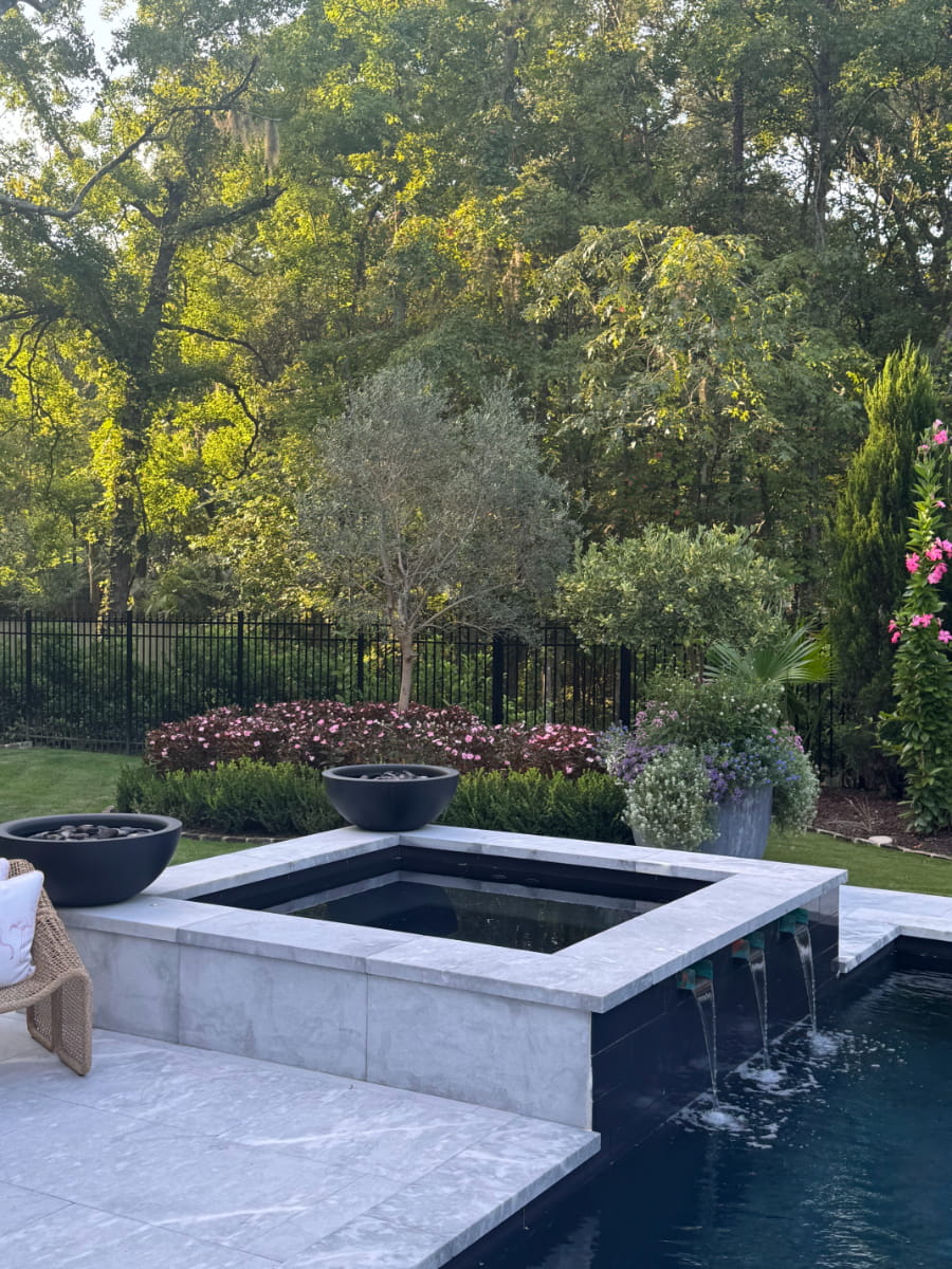 Contemporary pool and spa surrounded by manicured ornamental plantings