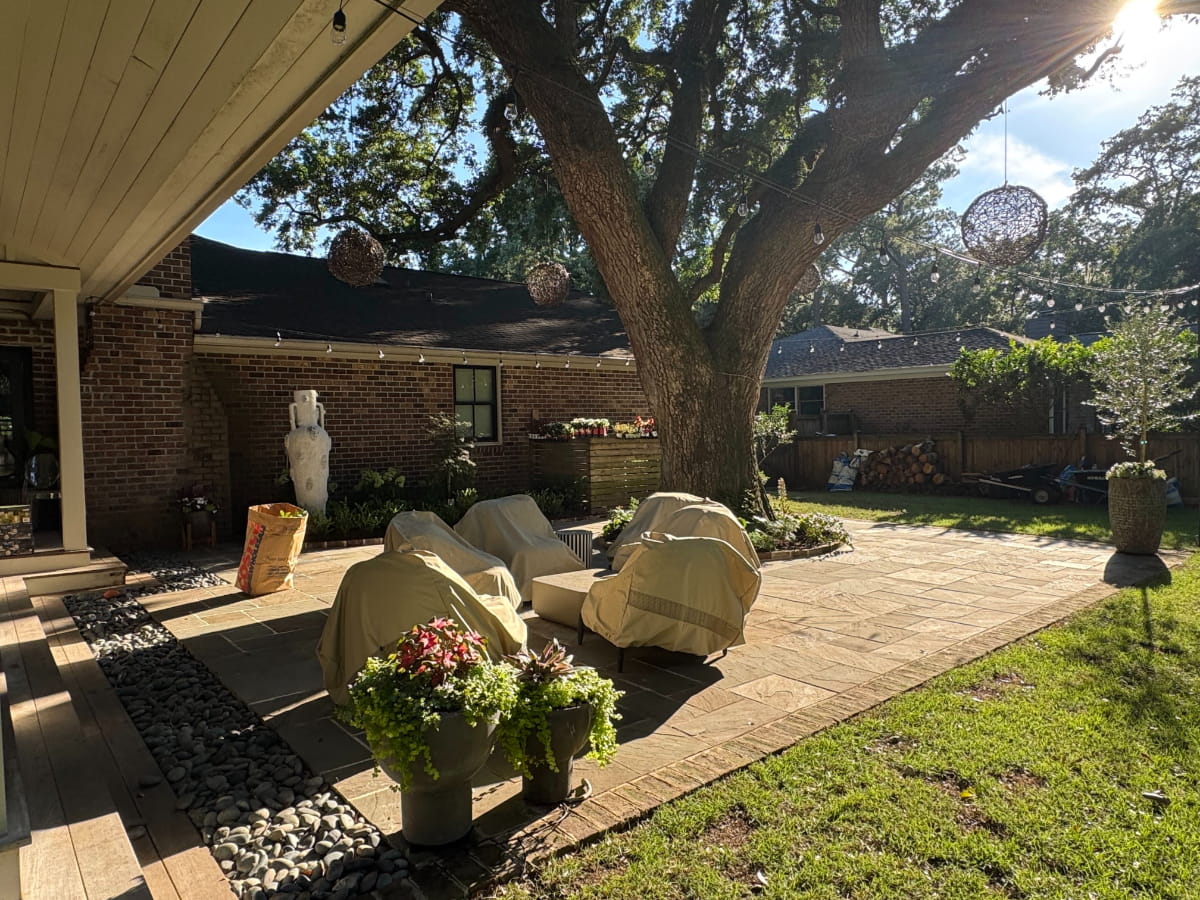 Sunlit outdoor living terrace beneath a mature live oak